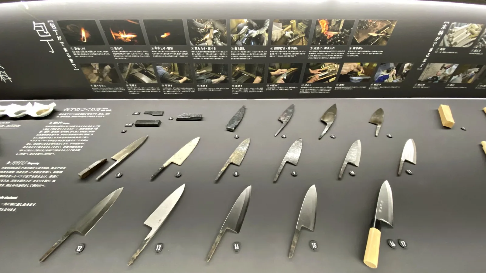 Display of 17 numbered stages of making a Sakai kitchen knife, from steel pieces to a finished deba with a wooden handle