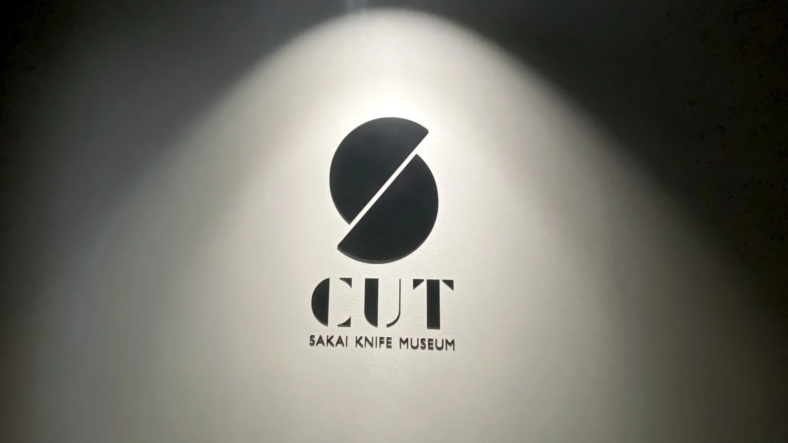 The CUT Sakai Knife Museum logo lit on a wall inside the museum