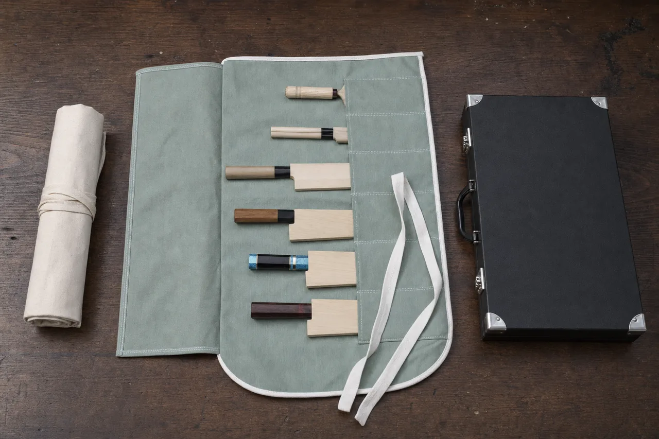 An off-white canvas knife roll, an open grey-green cotton knife pouch with six pockets, and a closed black attache knife case