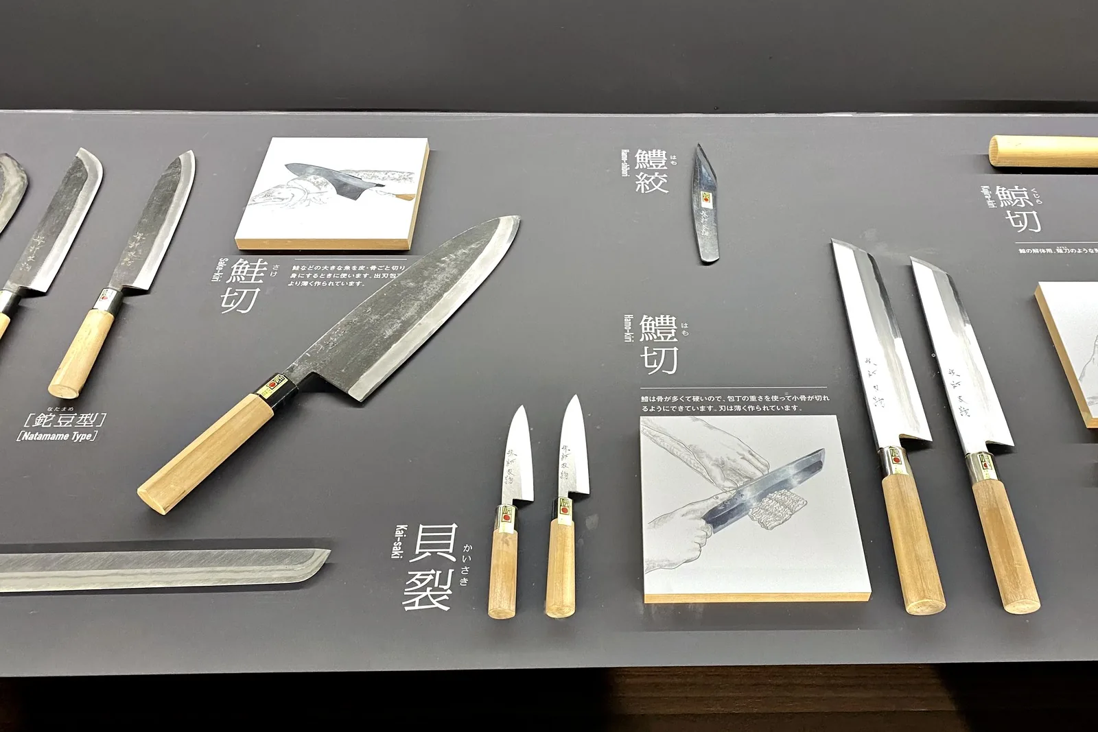 Specialized Japanese knives for eel, shellfish and whale displayed with small illustrated cards